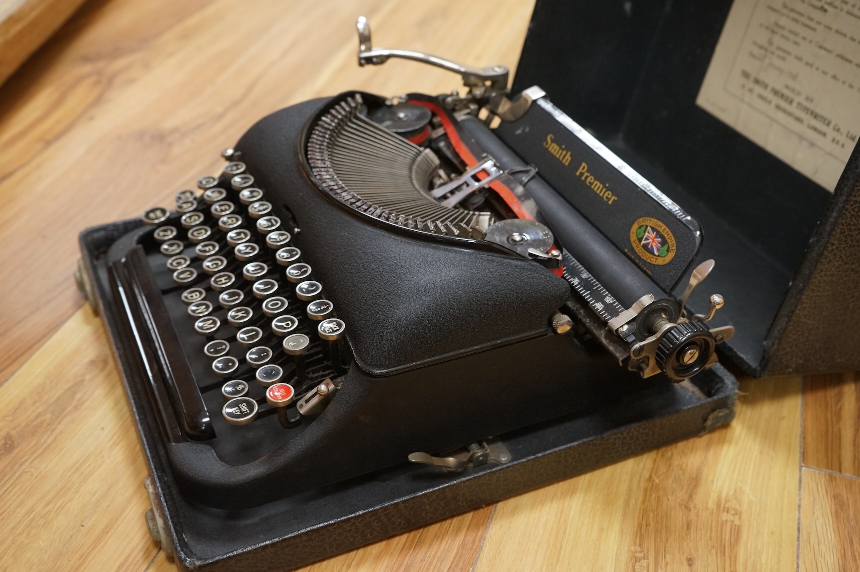 A cased portable Smith Premier Model 5 typewriter, with original guarantee sales label to the inside of the lid dated 22 January 1946.